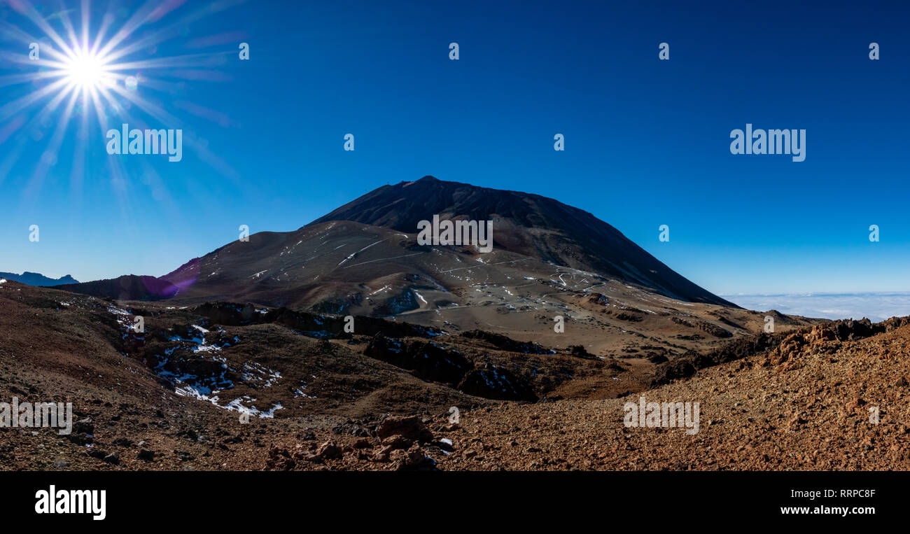 Teide mountain emerging in Tenerife against blue sky Stock Photo - Alamy