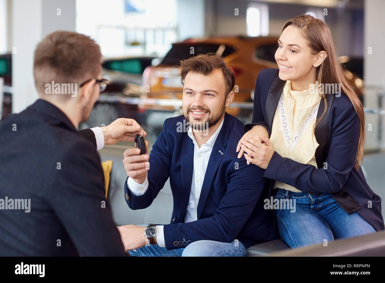 The dealer gives the keys to the new car to the customer Stock Photo