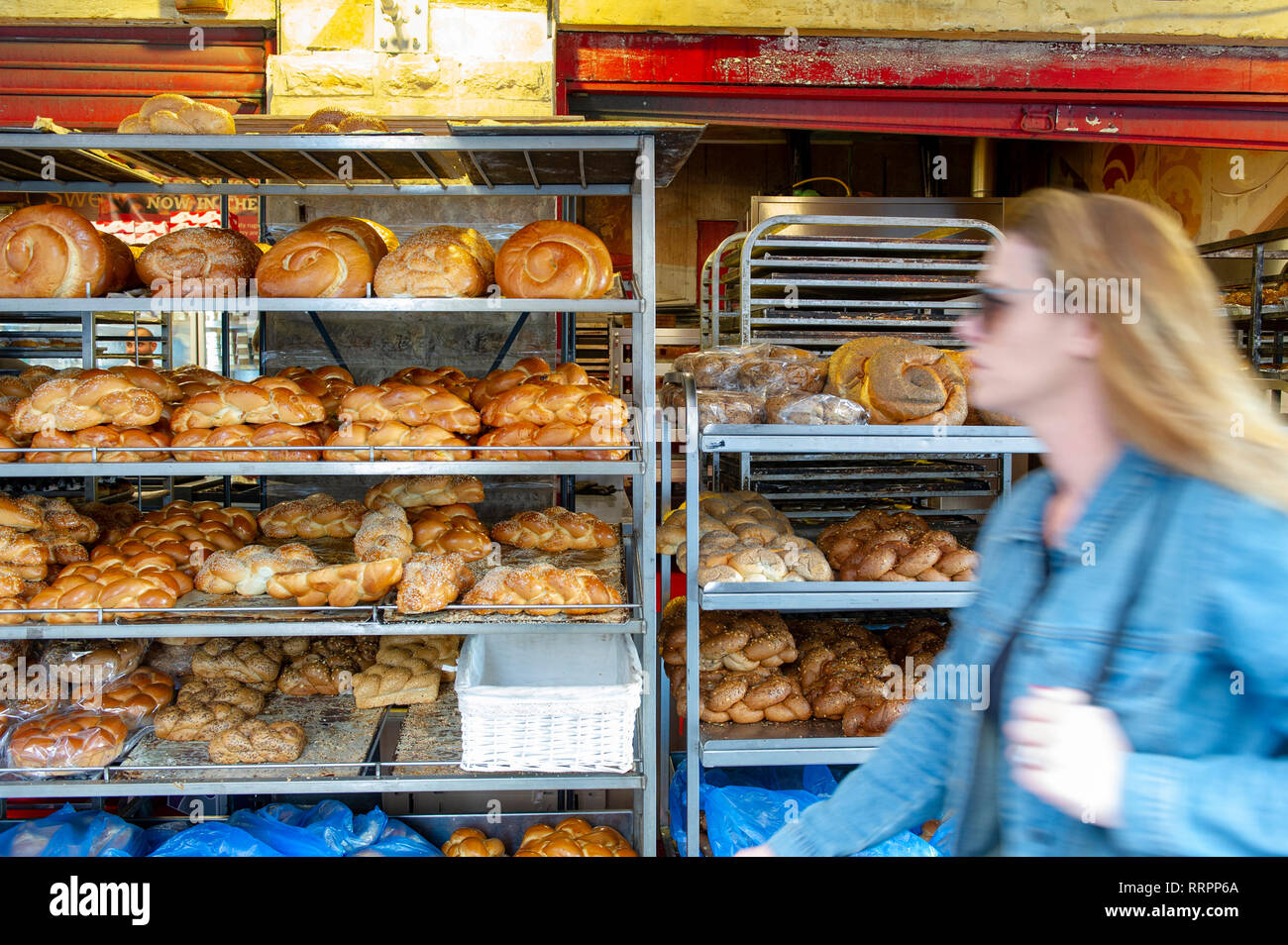 Blurred young woman walking in front of a bakery at Yehuda Market in Jerusalem, Israel Stock Photo