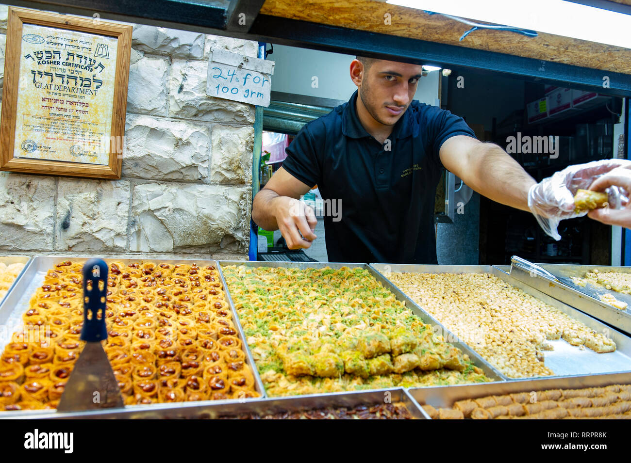 A vendor selling traditional pastries atl Yehuda Market in Jerusalem, Israel Stock Photo