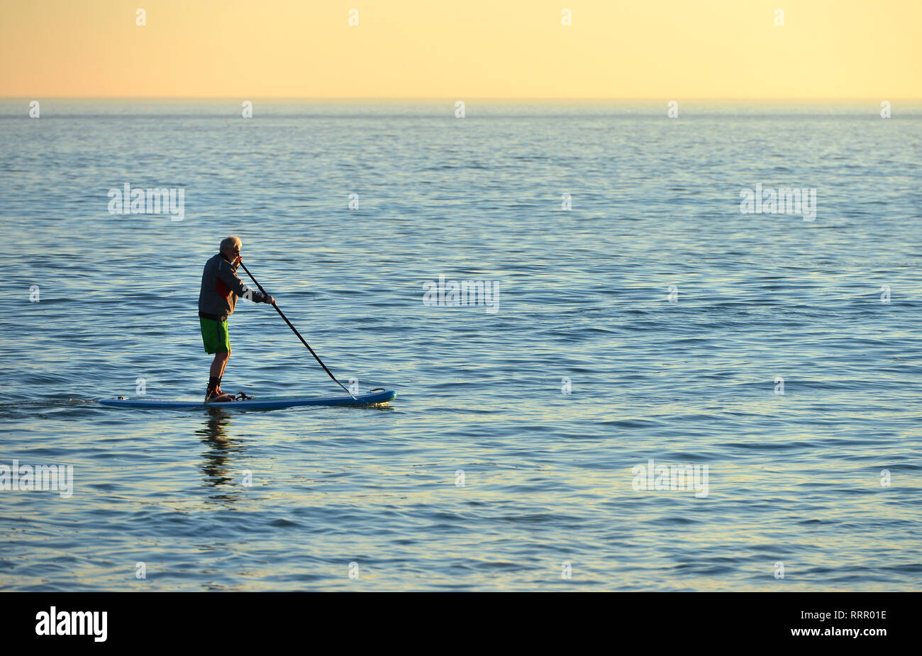Seaford, East Sussex, UK. 26th Feb, 2019. A man in shorts paddle boarding in Seaford on the hottest winter day on record. Credit: Peter Cripps/Alamy Live News Stock Photo