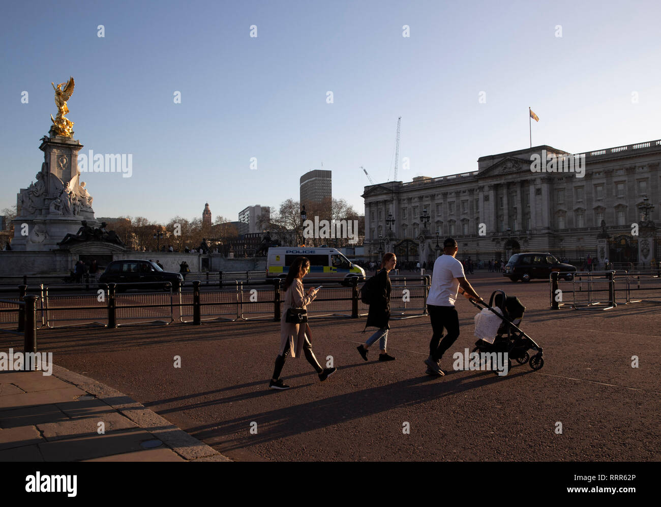 London, Britain. 26th Feb, 2019. People pass by the Buckingham Palace in London, Britain, on Feb. 26, 2019. Britain experienced its warmest February day on record Monday as the highest temperature reached 20.3 degrees Celsius in Wales. It was also the first time that a temperature exceeding 20 degrees in winter was recorded. It broke Britain's record of the highest February temperature of 19.7 degrees set at Greenwich in 1998. Credit: Han Yan/Xinhua/Alamy Live News Stock Photo