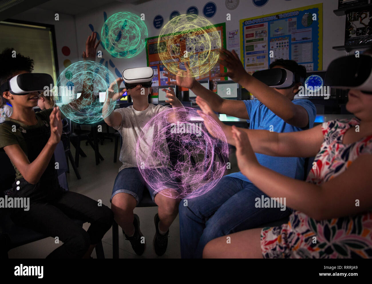 Junior high school students using virtual reality simulators in dark classroom Stock Photo