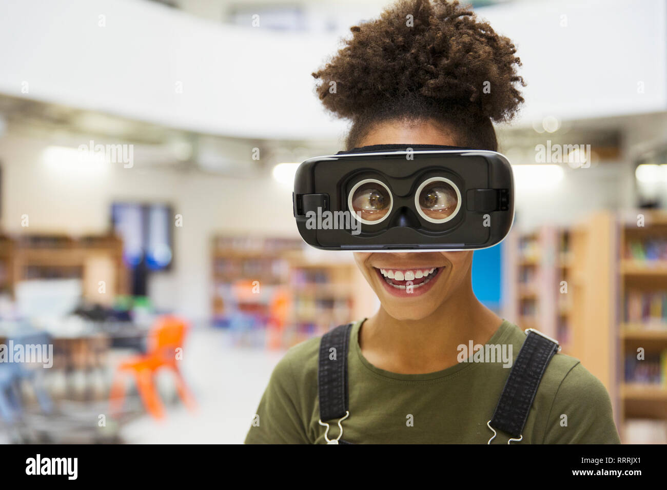 Portrait playful junior high girl student wearing virtual reality glasses Stock Photo