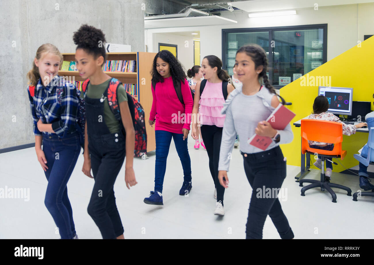 Junior high girl students walking in library Stock Photo