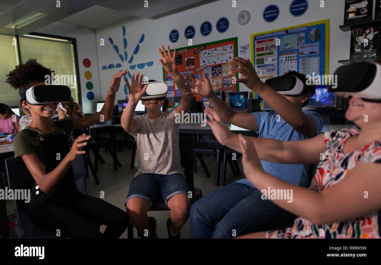 Junior high school students using virtual reality simulators in classroom Stock Photo