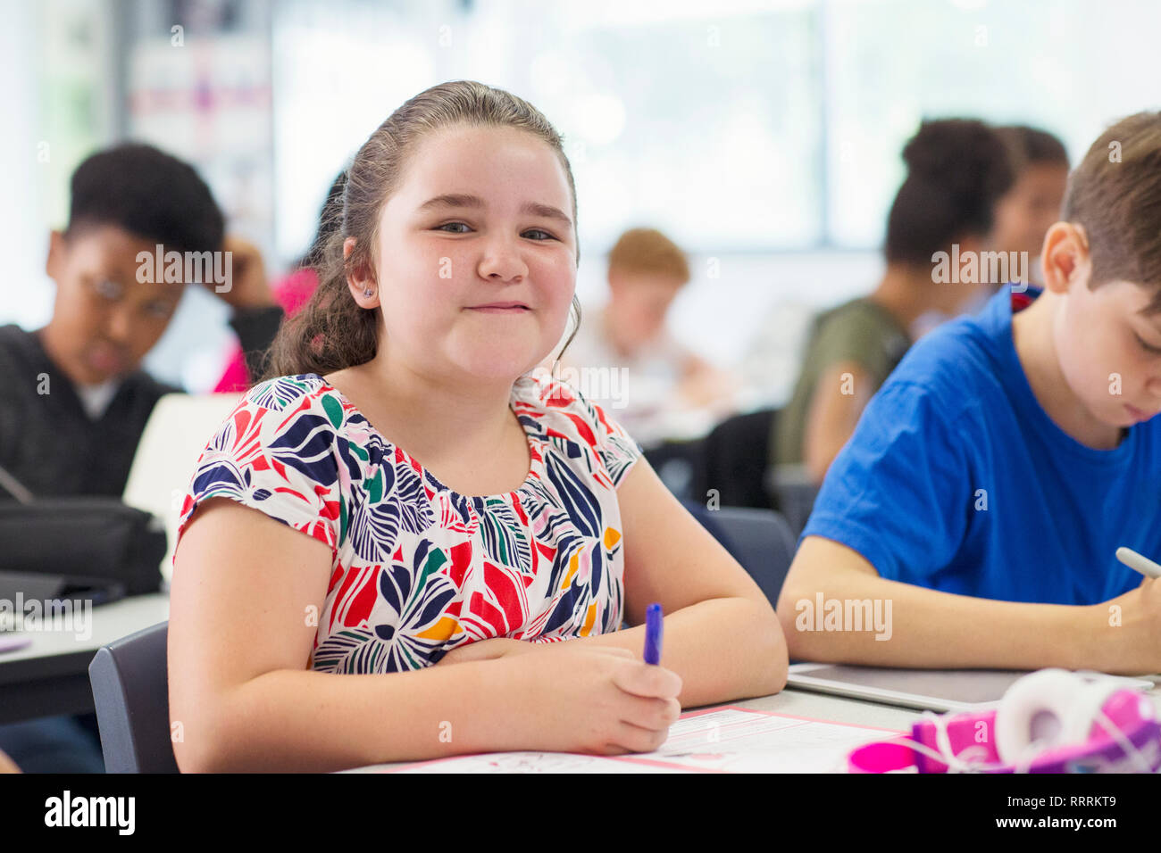 Portrait smiling, confident junior high school girl studying in classroom Stock Photo