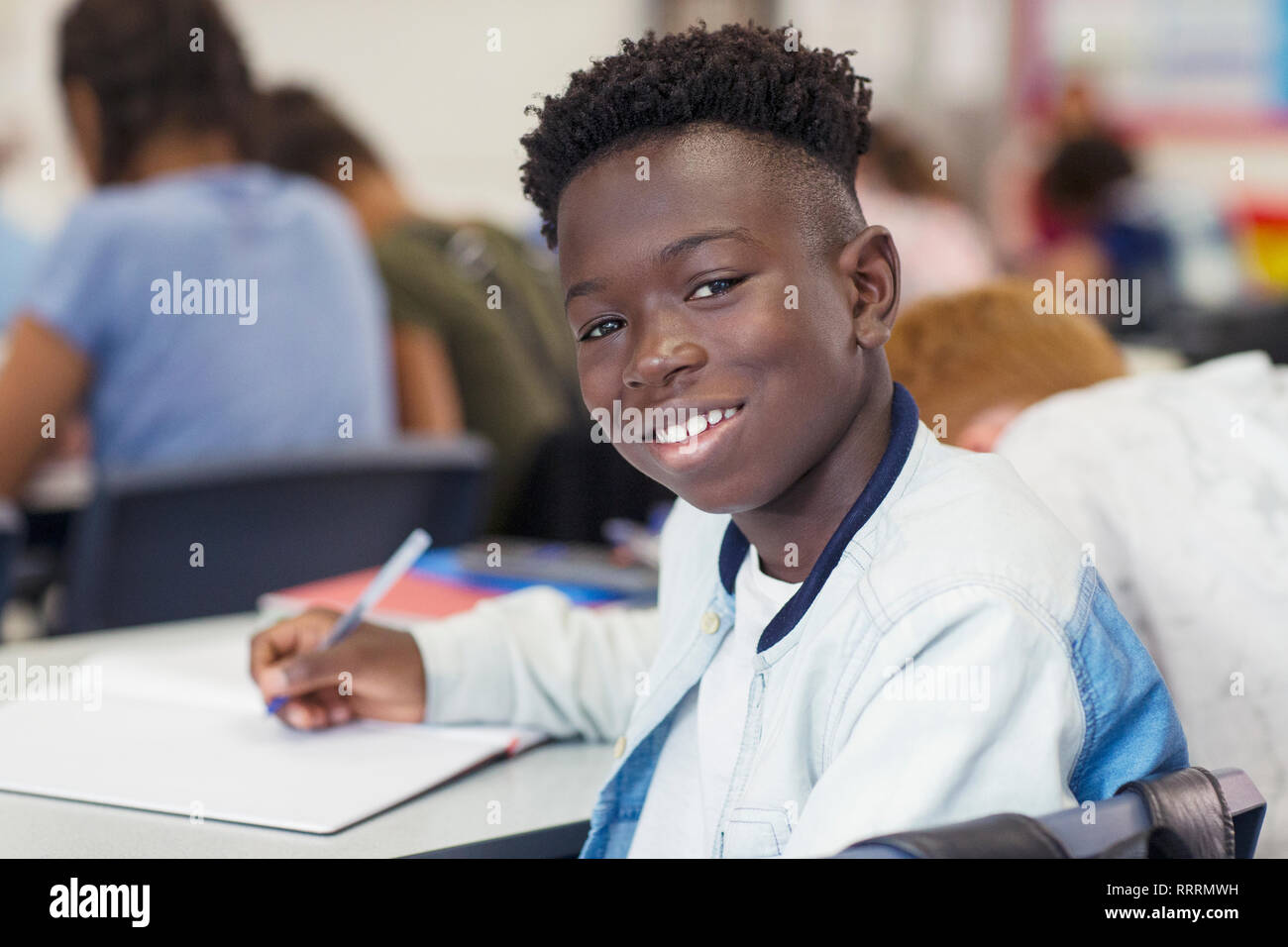 Portrait confident junior high school boy studying in classroom Stock Photo