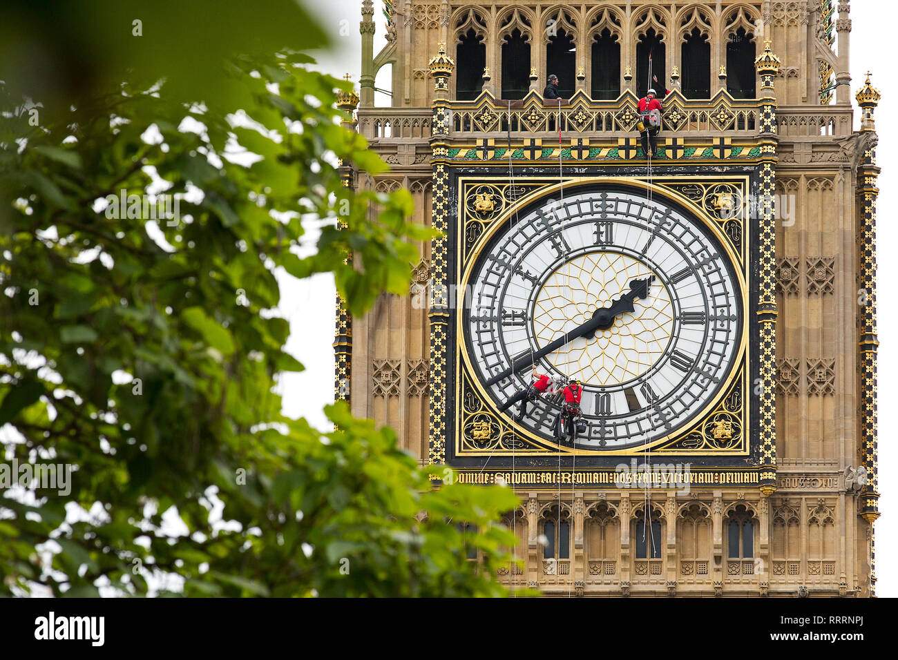 Workers clean the clock face of the Elizabeth Tower (Big Ben) of the Houses of Parliament on August 21, 2014. Stock Photo