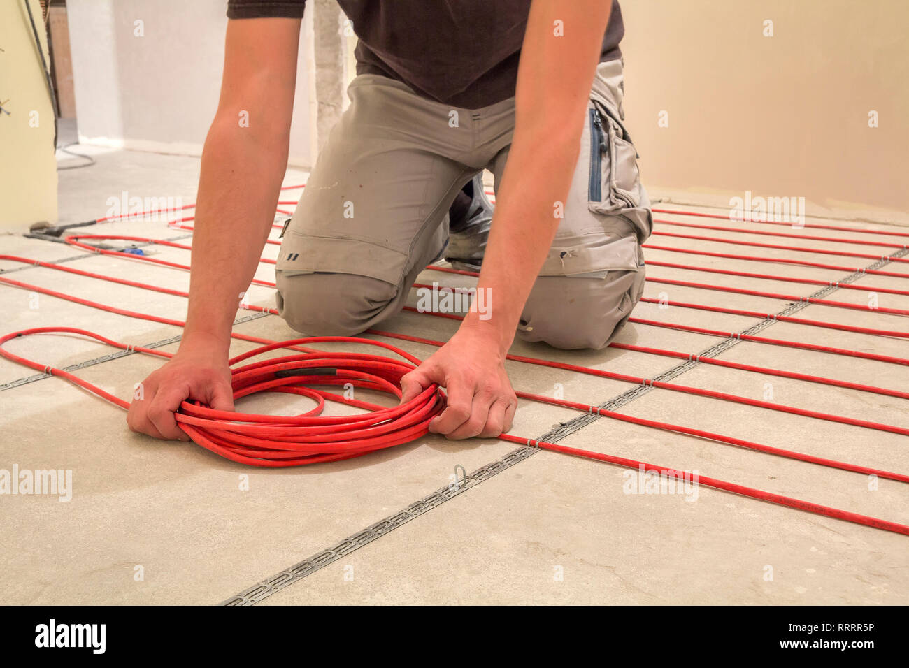 Electrician Installing Heating Red Electrical Cable Wire On