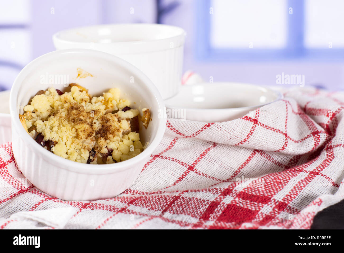 Recipe step by step crumble with fruits one serving closeup in a ceramic ramekin with blue