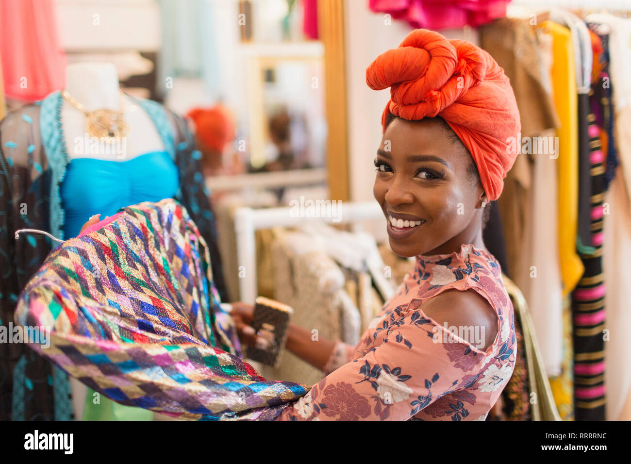 Portrait smiling, confident young woman in headscarf shopping in clothing store Stock Photo