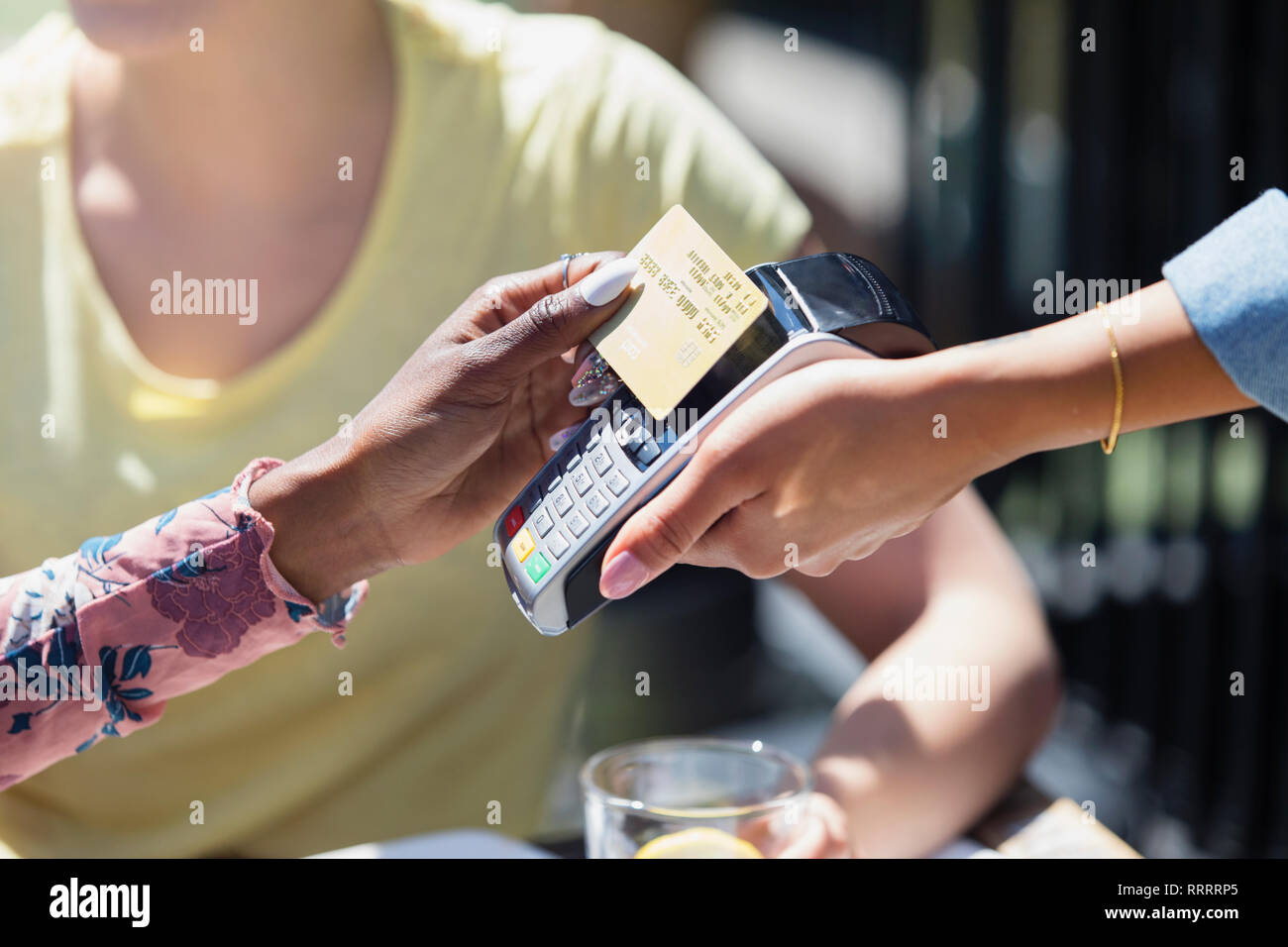 Woman paying waitress with smart card Stock Photo