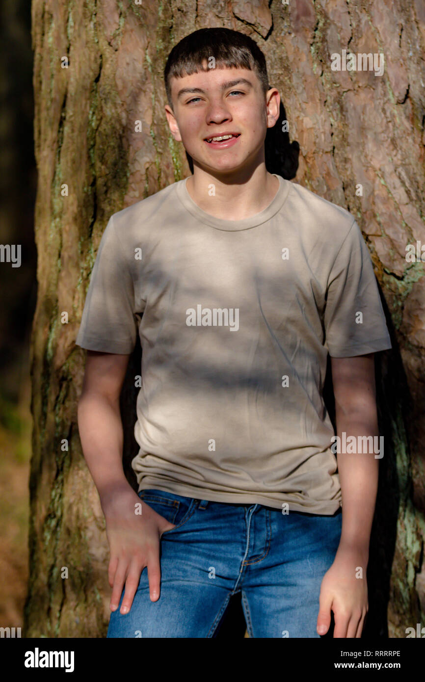 Teenage boy leaning against tree hi-res stock photography and images ...