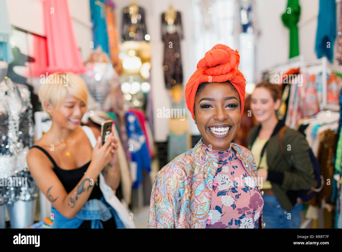 Portrait enthusiastic young woman shopping with friends in clothing store Stock Photo