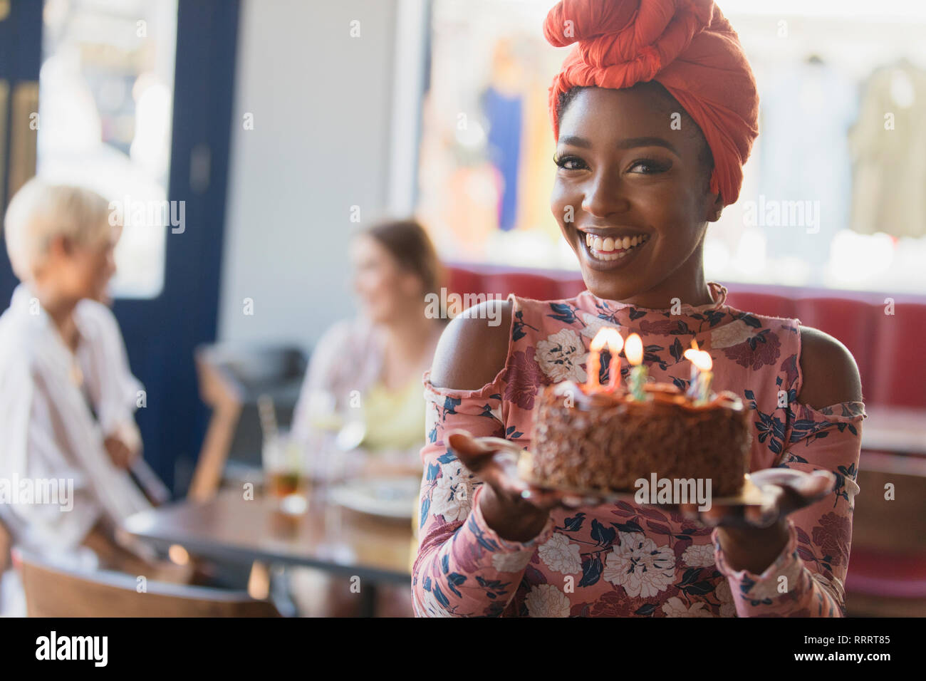 Portrait smiling, confident young woman holding birthday cake with candles Stock Photo