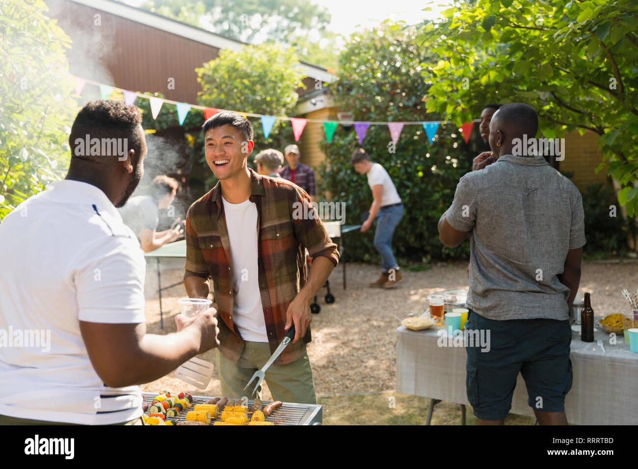 Male friends enjoying backyard summer barbecue Stock Photo