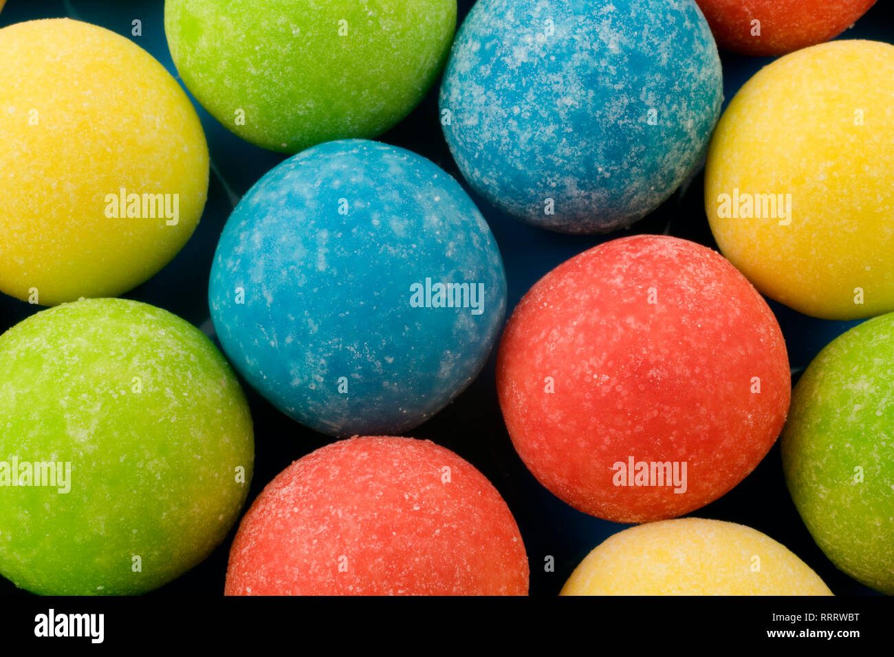 Close-up of frosted gum ball candies on a blue plastic background Stock Photo