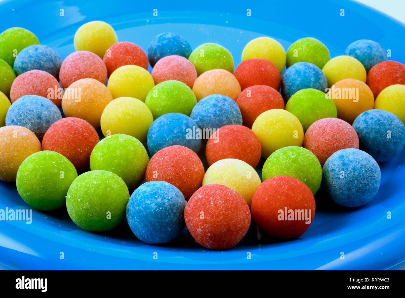 Close-up of frosted gum ball candies in a blue plastic plate Stock Photo