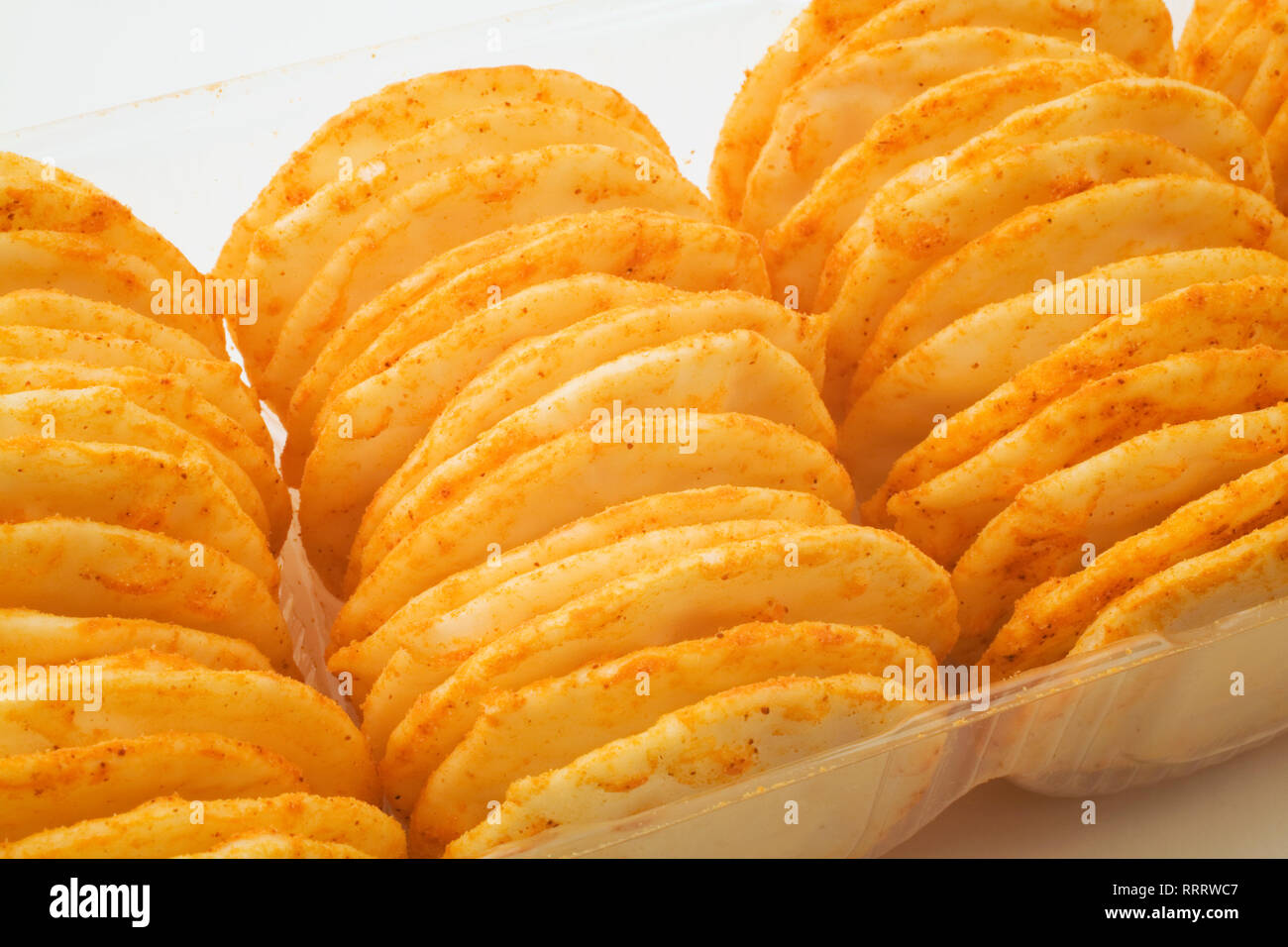 Cheddar cheese rice crackers in a clear plastic packaging tray Stock