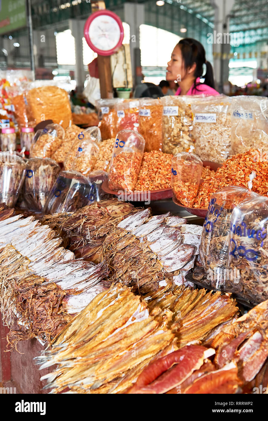 Cha-am, Phetchaburi, Thailand - June 25, 2011: Female vendor selling a variety of salted dried fish, squid and seafood presented at the central market Stock Photo