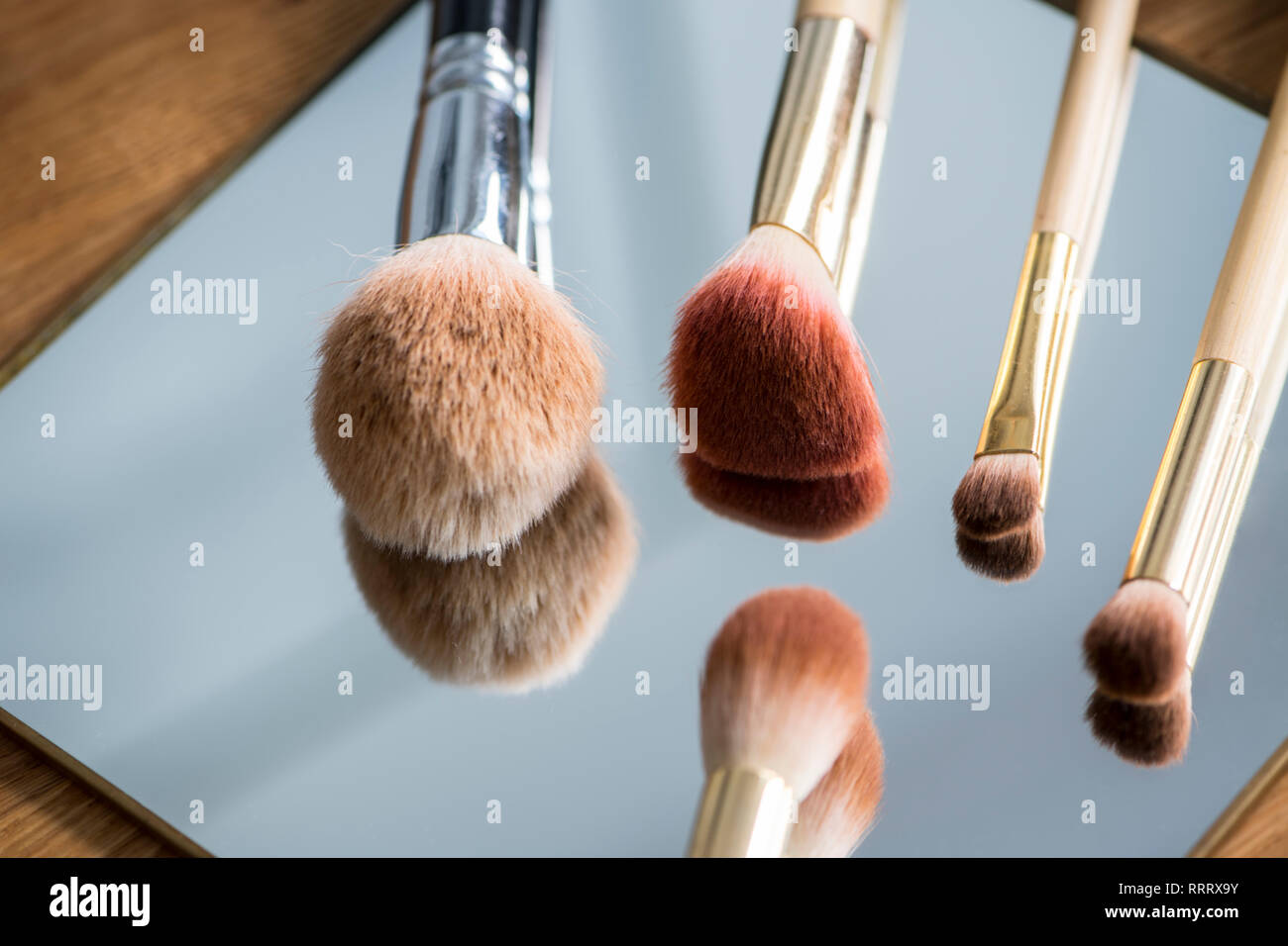 Different make-up brushes on a mirror Stock Photo