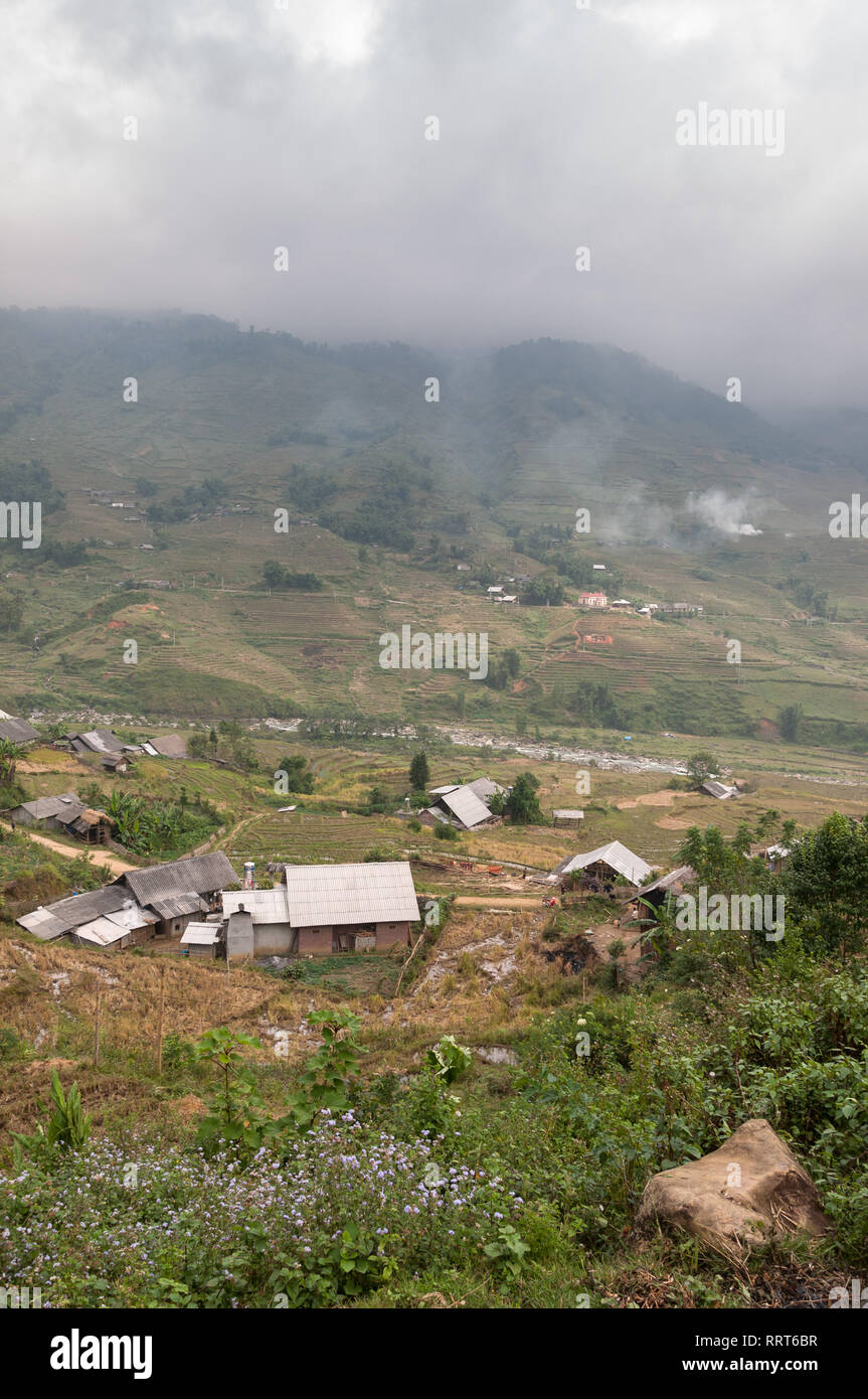 Terraced hills and farm houses in fog, Sa Pa, Vietnam Stock Photo