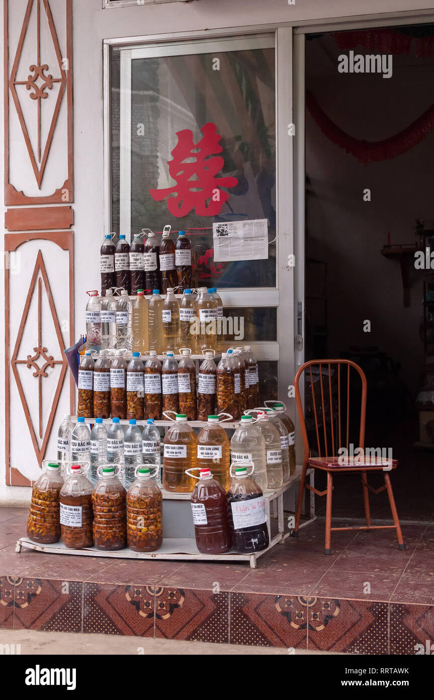 Plastic bottles of various rice wine stacked on display outside a small shop, Sa Pa, Vietnam Stock Photo