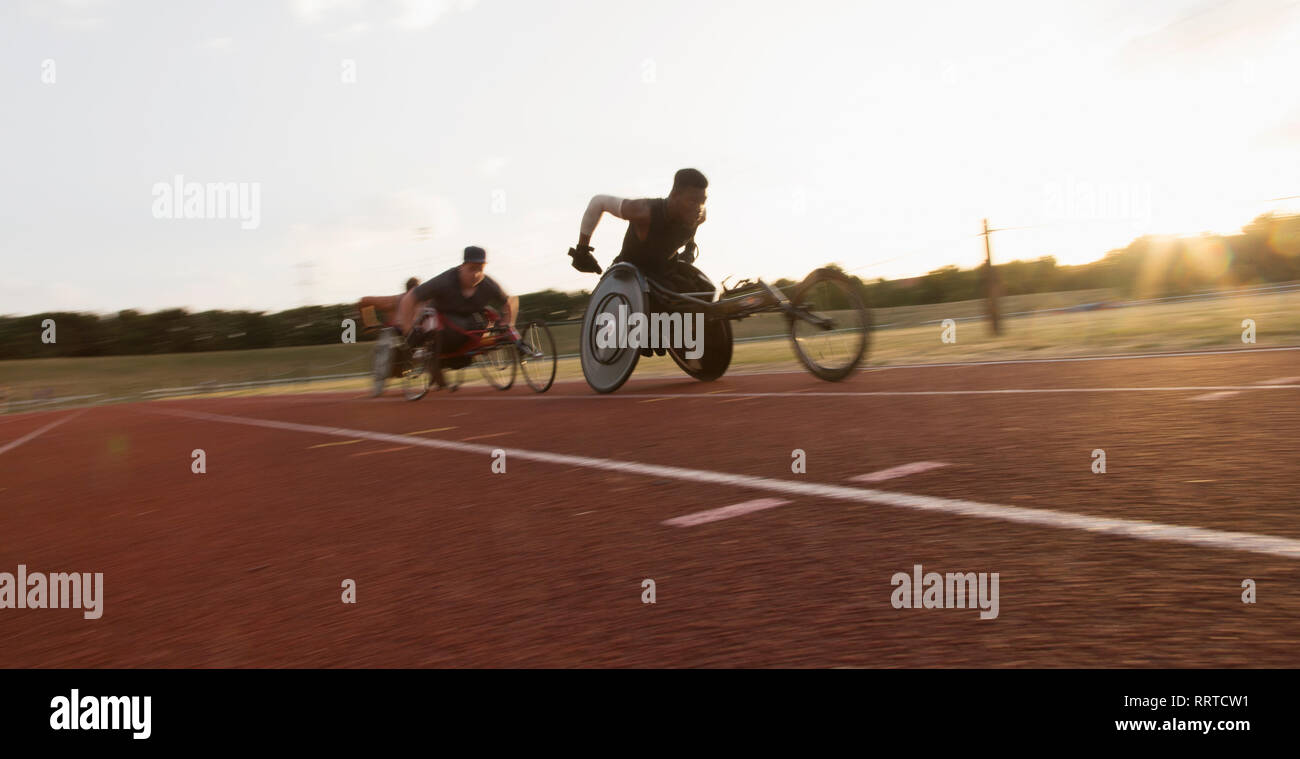 Paraplegic athletes speeding along sports track during wheelchair race Stock Photo