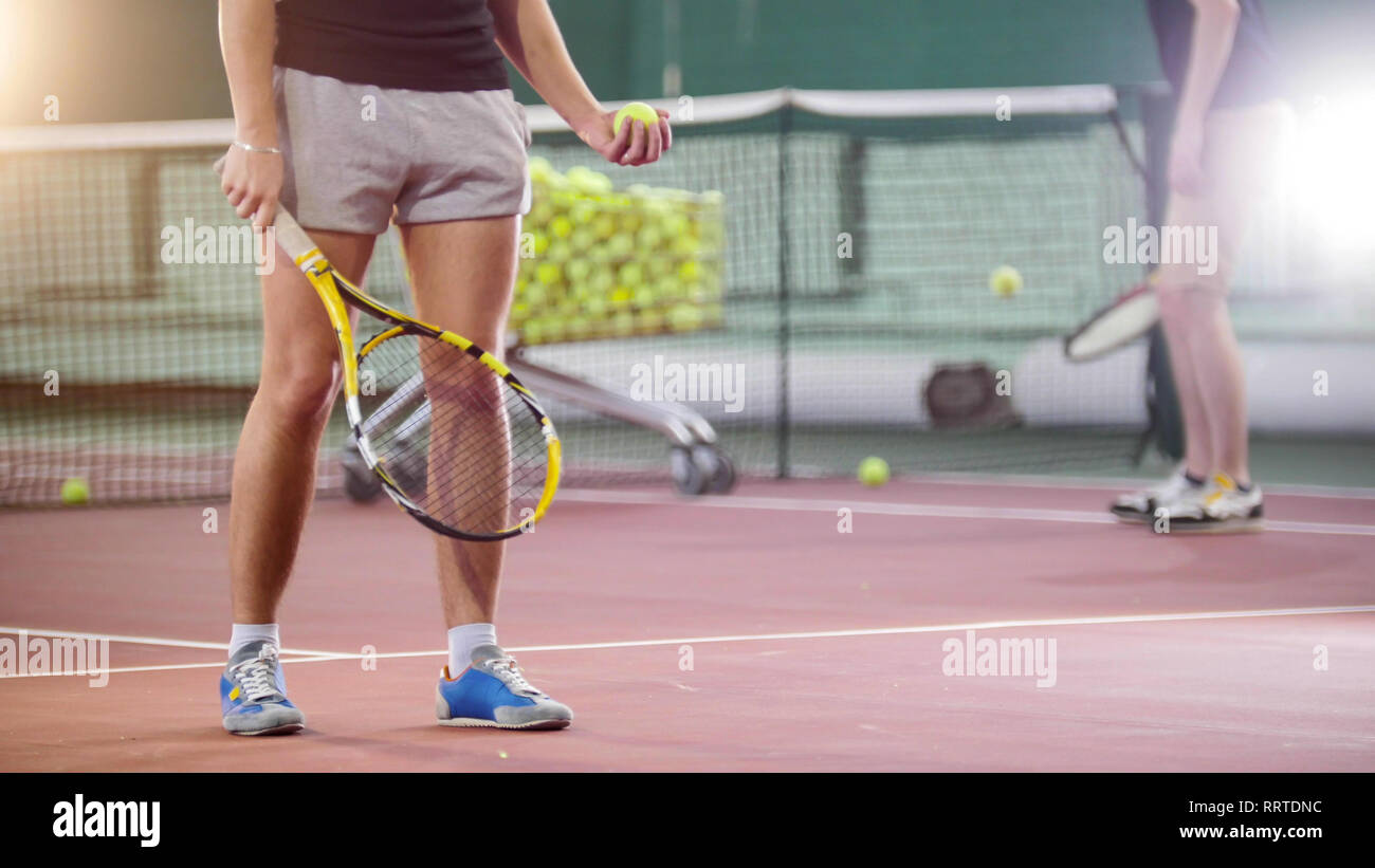 Tennis. Young men hitting the ball from the floor Stock Photo