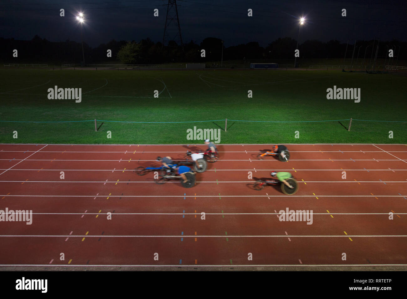 Paraplegic athletes speeding along sports track in wheelchair race at