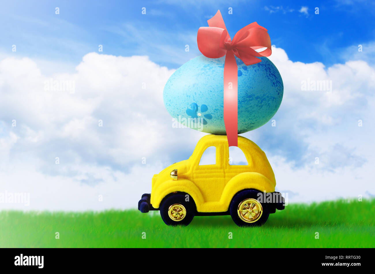Retro toy car with Easter egg on the roof. on spring background Easter concept. Happy Easter. Stock Photo