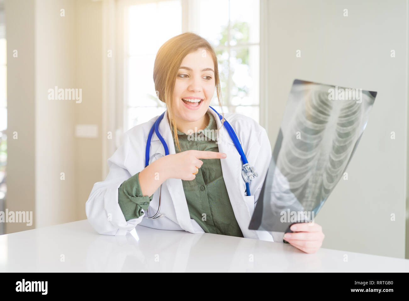 Beautiful young doctor woman looking at chest radiography very happy ...