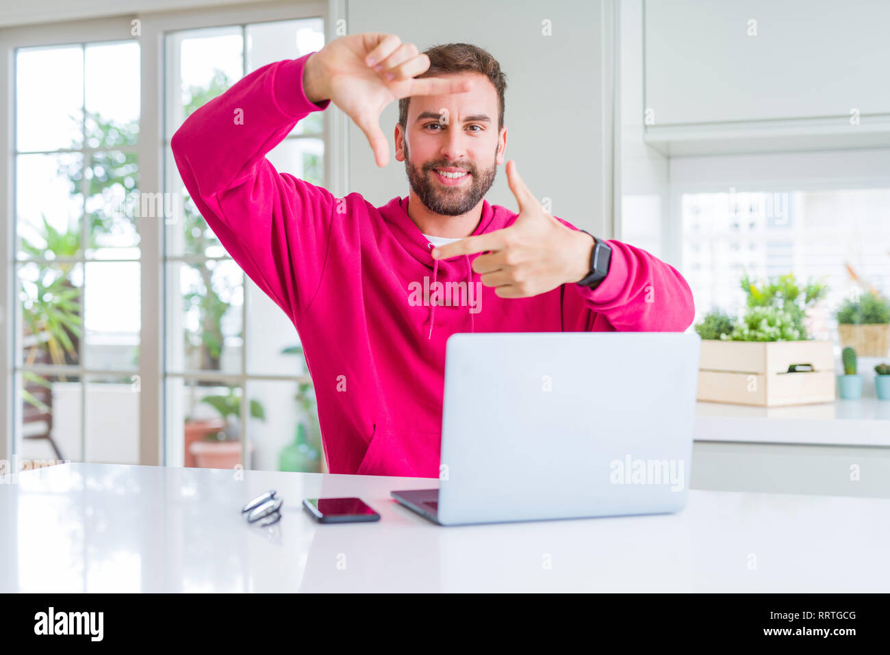 Handsome man working using computer laptop smiling making frame with ...