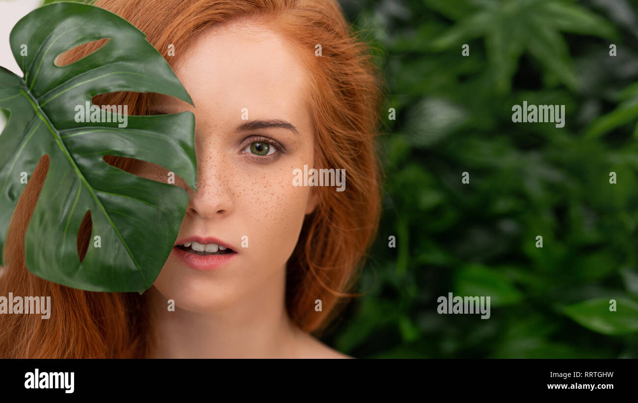 Portrait of young and beautiful woman in tropical leaves Stock Photo