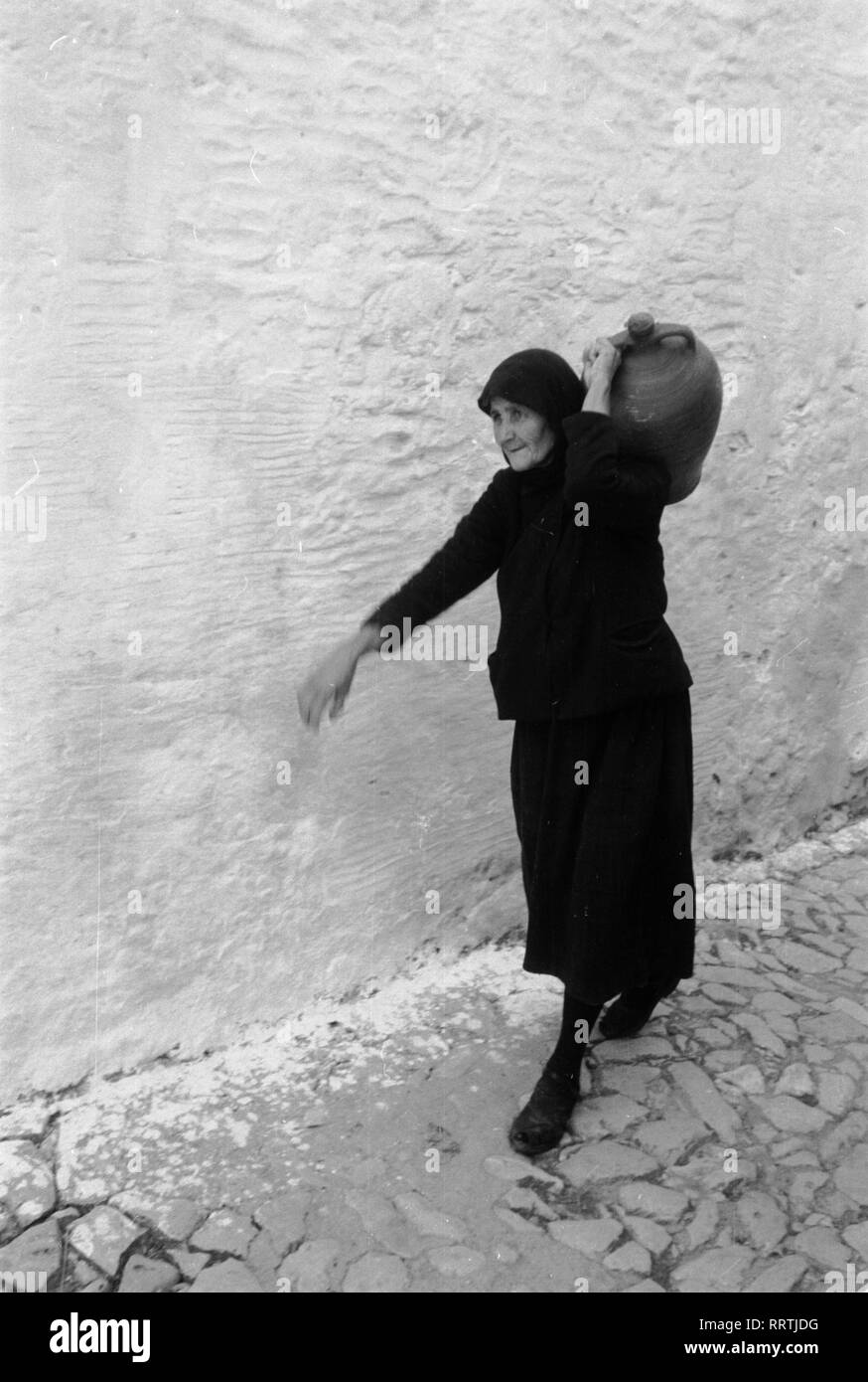 Travel to Greece - Greece - old woman from Mykonos island, Cyclades. Image date circa 1954. Alte Frau trägt einen Krug auf der Insel Mykonos, Griechenland 1954.  Photo Erich Andres Stock Photo