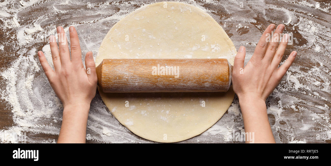 Chef rolling dough for pizza on table Stock Photo