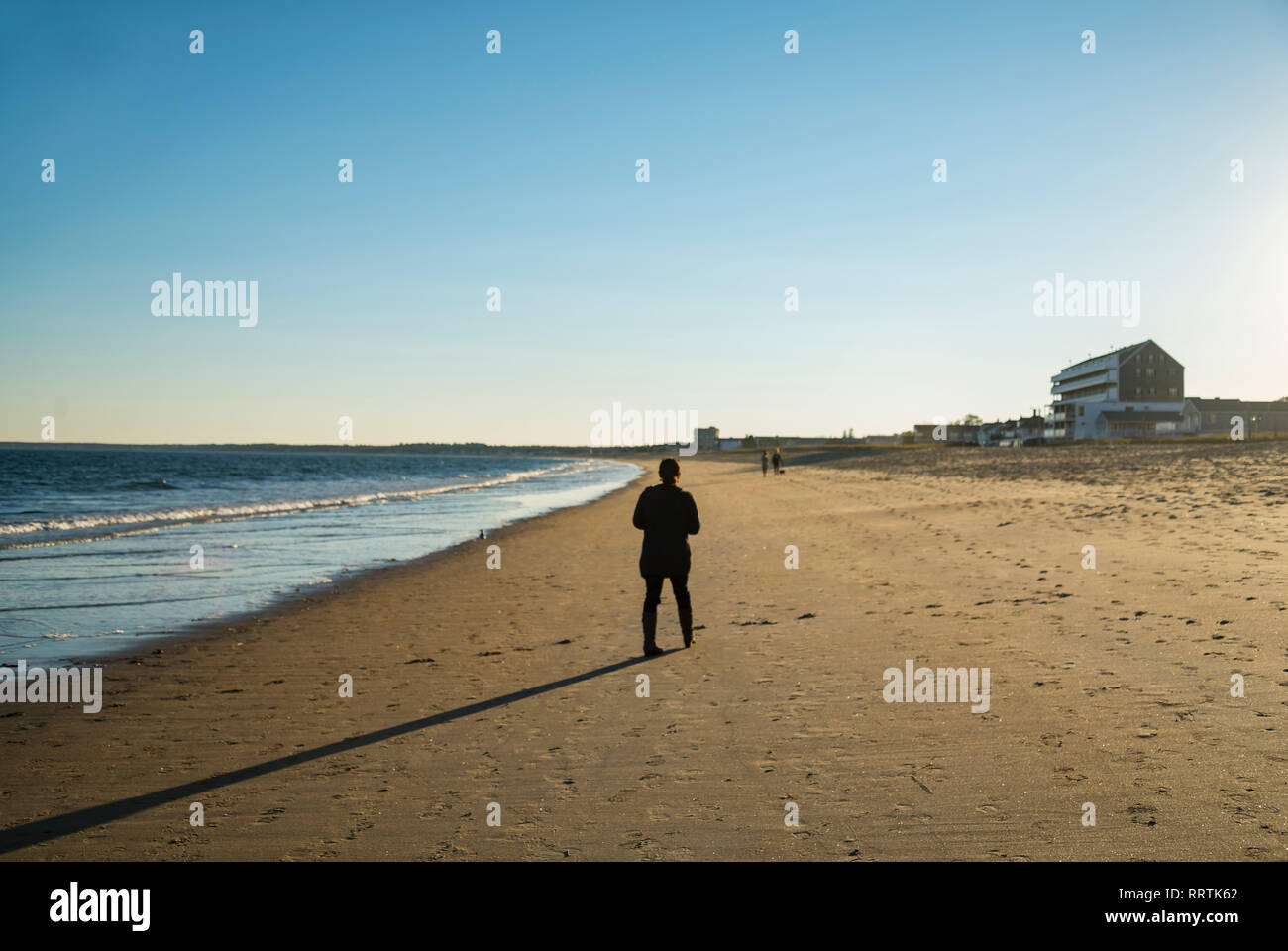 solitary old man walking on the beach Stock Photo
