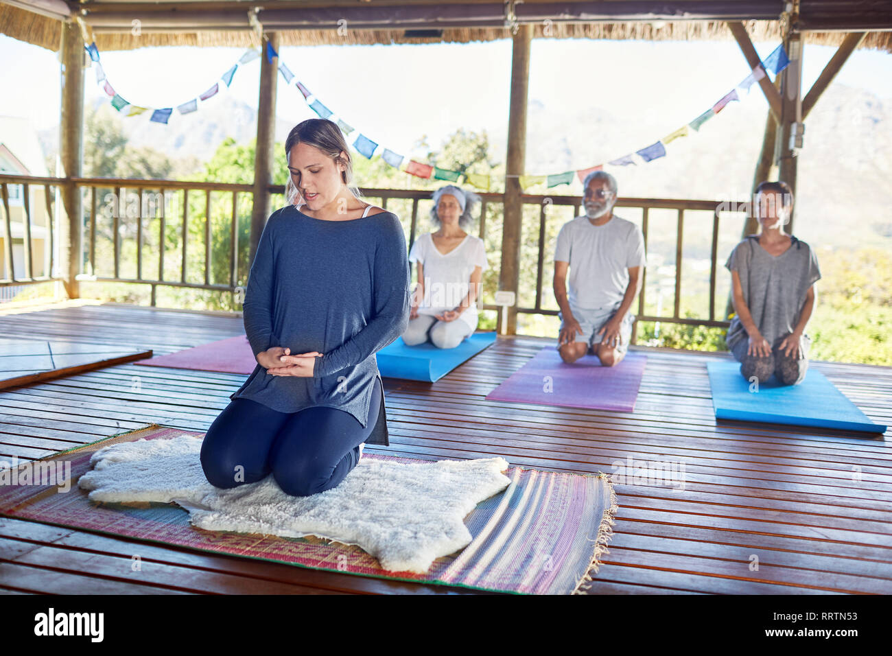 People meditating during yoga retreat in hut Stock Photo