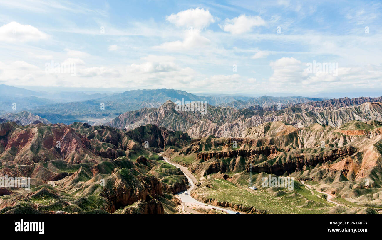 Aerial View of Binggou Danxia Canyon Landform in Zhangye, Sunan Region, Gansu Province, China. Sharp Pointy Peaks in the Geopark. Road on Valley on a  Stock Photo