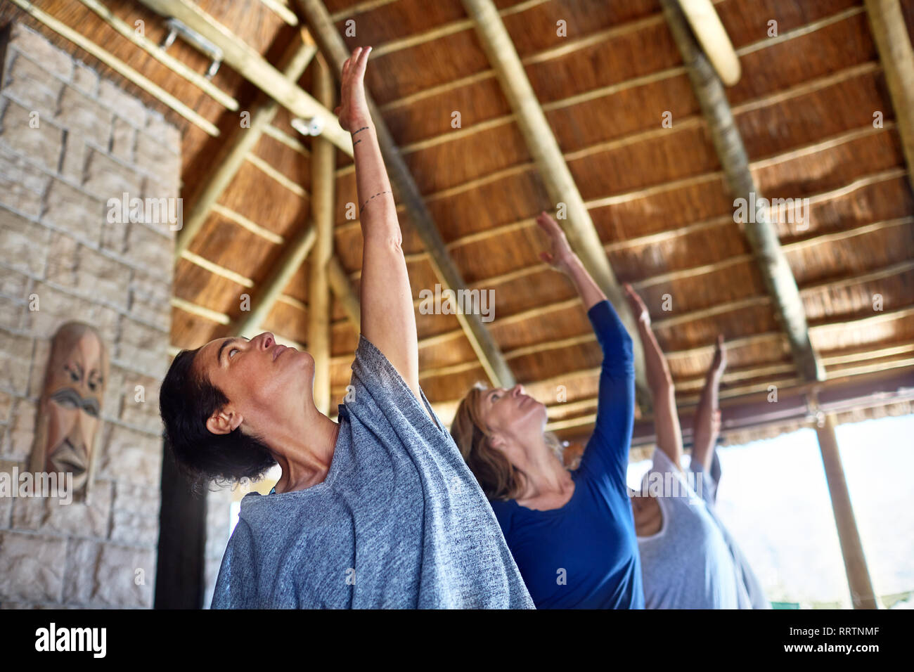 Women practicing yoga during retreat in hut Stock Photo