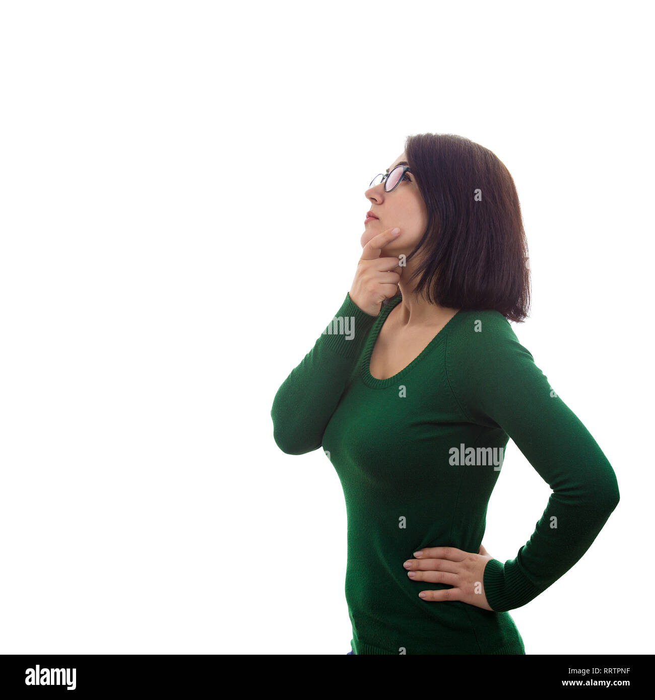 Side view portrait of pensive young woman student holding one hand under chin and another on hips looking up and thinking isolated over white backgrou Stock Photo