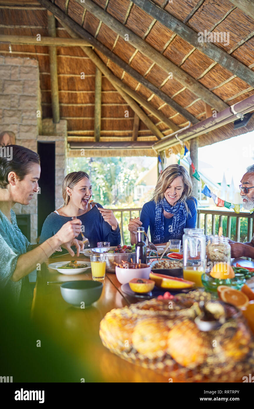 Friends enjoying healthy meal in hut during yoga retreat Stock Photo