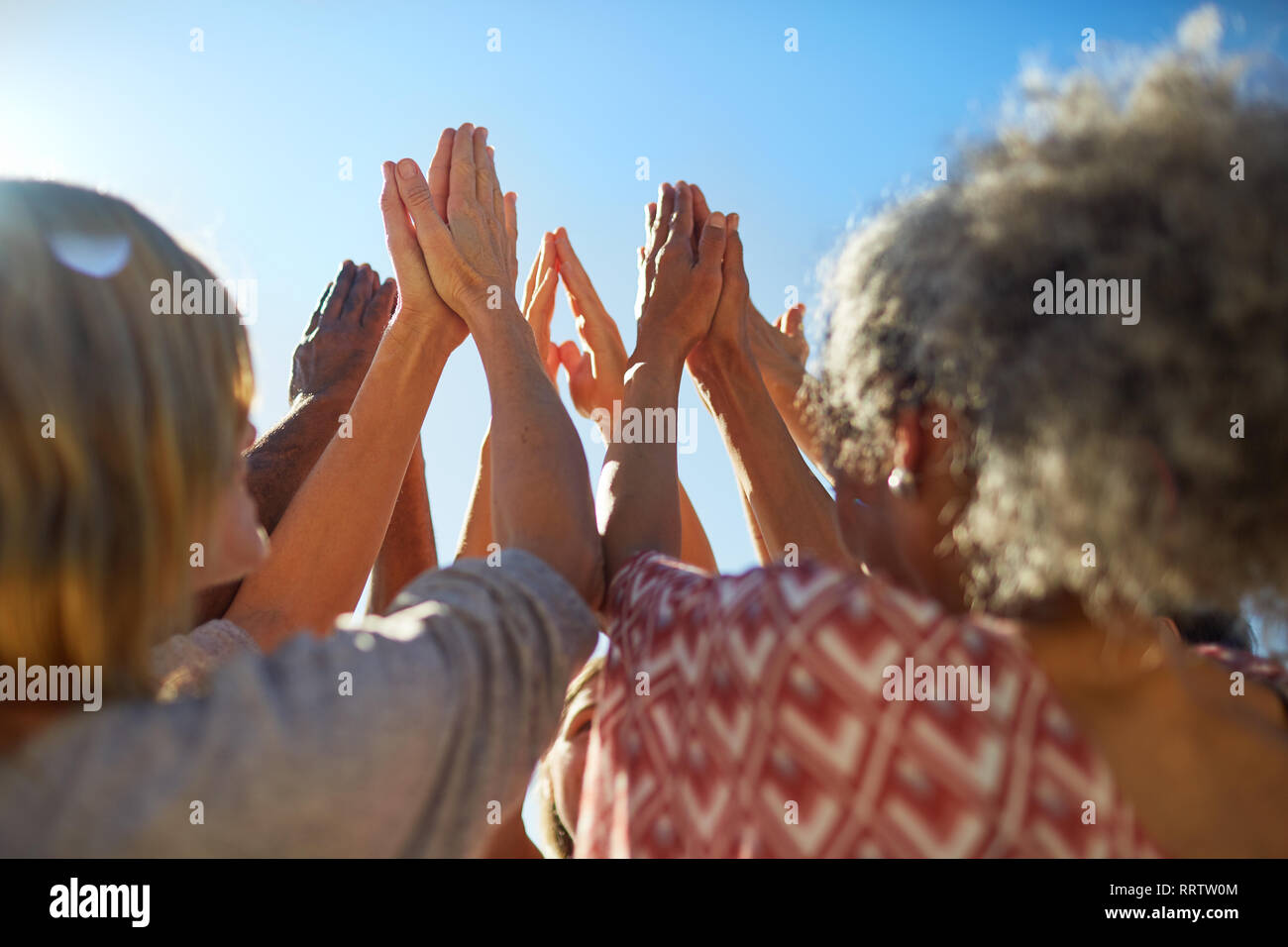 Group with hands clasped in circle during yoga retreat Stock Photo
