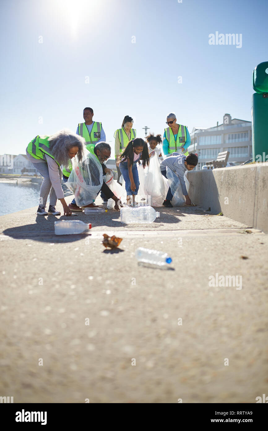 Volunteers picking up plastic litter on sunny boardwalk Stock Photo