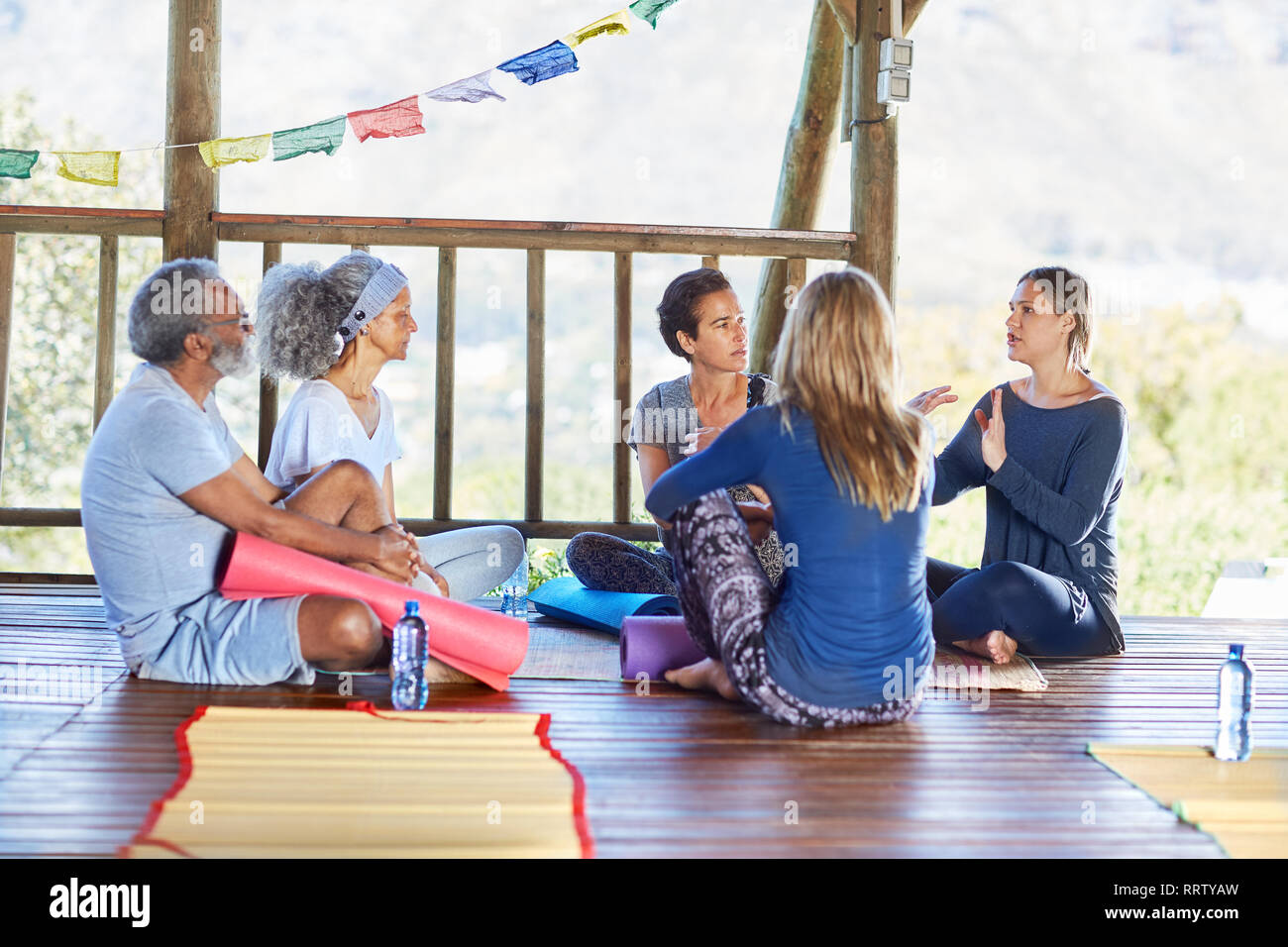 Yoga class talking in circle in hut during yoga retreat Stock Photo