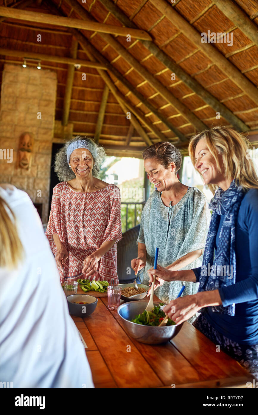 Women preparing healthy meal in hut during yoga retreat Stock Photo