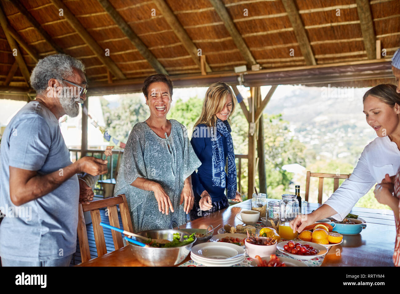 Happy friends enjoying healthy meal in hut during yoga retreat Stock Photo