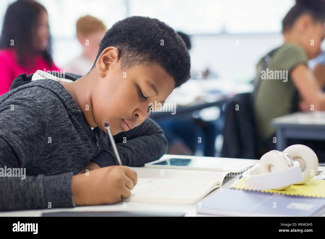 Junior high school boy student doing homework in classroom Stock Photo