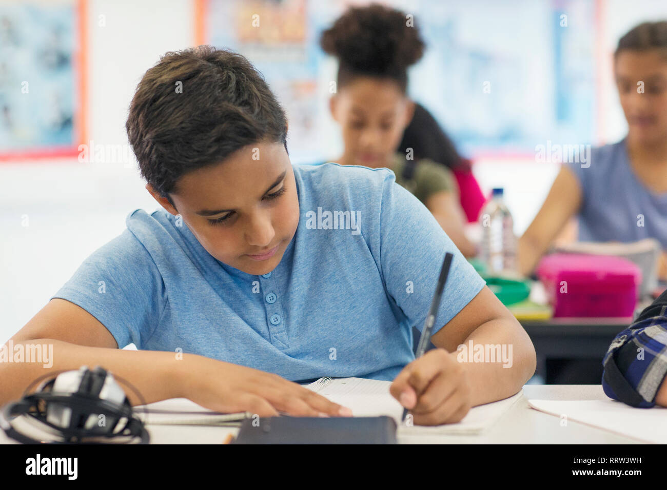Junior high school boy student doing homework in classroom Stock Photo